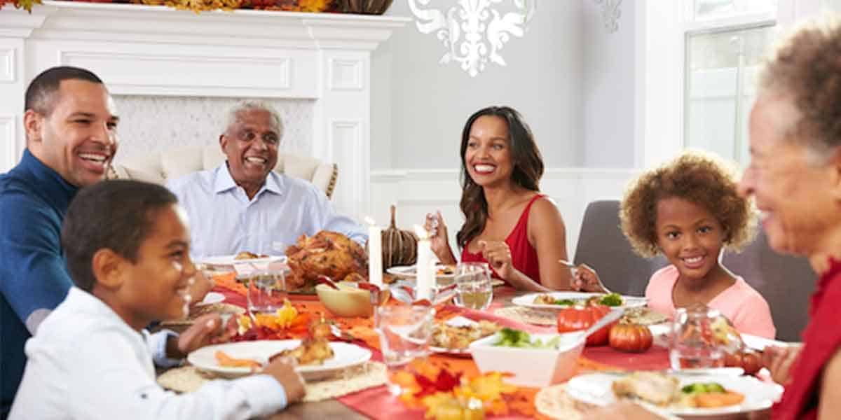 A happy family gathered around the Thanksgiving table, enjoying a delicious meal.