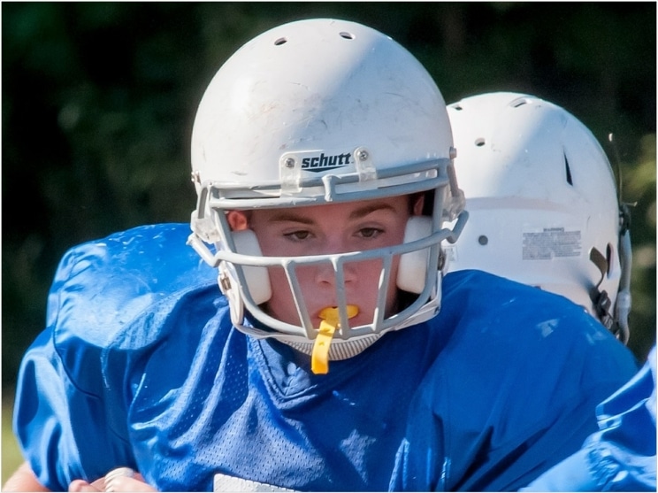 A young athlete confidently wearing a custom-fit sports mouth guard for maximum dental protection.